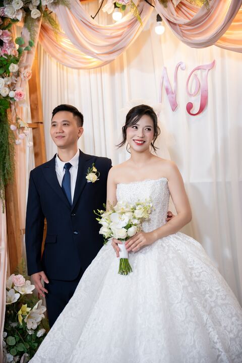 Cô dâu chú rể chụp ảnh bên cổng hoa trong ngày cưới
